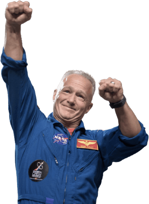 Douglas Hurley: A middle-aged man wearing a NASA blue flight suit, lifting his hands up in a gesture of celebration, and smiling